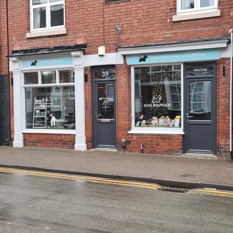 The shopfront at 39 High Street, Ibstock: a red-brick terraced premises with pale-blue fascia signs and white-framed windows on a wet morning